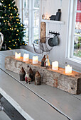 Weihnachtliche Tischdekoration mit Kerzen und kleinen Figuren