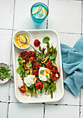 Asparagus with tomatoes and poached eggs with lemon mustard dressing