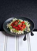 Meatballs in a spicy pepper sauce with orzo and arugula