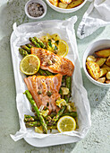 Salmon with green asparagus on parchment paper