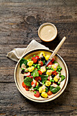 Gnocchi salad with spinach, peas, olives and tomatoes