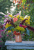 Blumenstrauss mit Fuchsschwanz (Amaranthus caudatus), Cosmea (Cosmos), Goldrute (Solidago), Herbstastern, Chinaschilf, Rose in Steinkrug