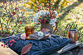 Autumn garden table with bouquet of ornamental apple and chrysanthemums (Chrysanthemum)
