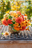 Blumenstrauß auf Terrassentisch, Dahlien (Dahlia), Ringelblume (Calendula) und Kapuzinerkresse (Tropaeolum), Herbststimmung
