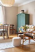 Bright living area with green vintage cupboard and wooden furniture