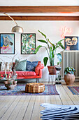 Bright red sofa, pictures, neon sign and houseplants in the living room