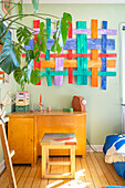 Colorful wall hanging with vintage desk below