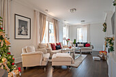 Living room with Christmas tree, light-coloured upholstered furniture and dark floor