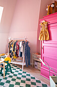 Kinderzimmer mit Kleiderständer und Schrank in Pink