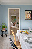 Dining room with blue walls and a view of the hallway and living room