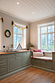 Seating window with cushions in a green country-style kitchen