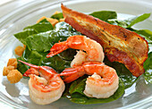 Spinach salad with shrimp and fried bacon