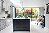 Airy kitchen and dining area with skylight and floor-to-ceiling glass doors to the terrace