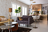 Living room with patterned sofa, copper-coloured pendant lights and photo wall