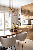 Dining area with pendant light and gold-coloured wall design