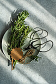 Fresh rosemary sprigs with clippers on plate