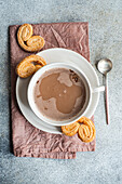 Cup of coffee with milk and cookies on the tray plate served on the concrete table