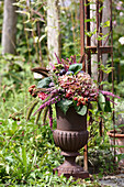 Amphora with autumn bouquet in the garden