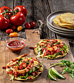 Tostadas with guacamole, lettuce, tomatoes and shrimp