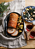 Roast porchetta with crispy potatoes and greens