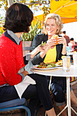 Two girlfriends eating outside