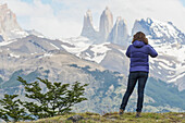 A Woman Stands With A View Of The Rugged Mountain Landscape, Torres Del Paine National Park; Torres Del Paine, Magallanes And Antartica Chilena Region, Chile