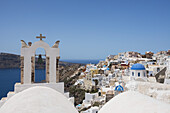 Glockenturm einer Kirche und traditionell bemalte Häuser mit Blick auf die Caldera; Oia, Santorin, Kykladen, Griechische Inseln, Griechenland