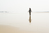 Junge Frau, die am Strand von Huohu, im Norden der Insel Kinmen, spazieren geht; Taiwan