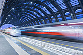 Motion Blur Of Speeding Train In Train Station; Milan, Lombardy, Italy