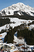 Mountains, Ski Slopes, Snow-Covered Wooden Houses And Fir Trees In The Alpine Ski Resort; Filzmoos, Austria