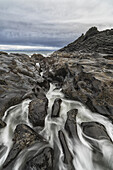 Wasser rauscht über das vulkanische Grundgestein im Bereich des Tow Hill an der Nordküste von Haida Gwaii, Naikoon Provincial Park; British Columbia, Kanada