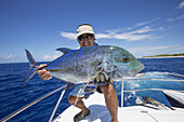Fischer hält einen frisch gefangenen Bube; Tahiti