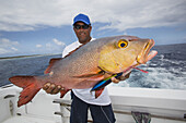 Fisherman Holding A Fresh Caught Red Snapper (Lutjanus); Tahiti