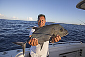 Fischer mit einem frisch gefangenen Jackfisch (Carangidae); Tahiti
