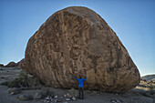 Person, die unter einem großen Felsbrocken im Richtersveld National Park steht; Südafrika