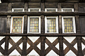 Nahaufnahme eines Fachwerkgebäudes und Details an der Seite eines Gebäudes mit Buntglasfenstern; Carhaix Plouger, Bretagne, Frankreich