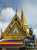 An Ornate And Colourful Building With A Statue Of Human Likeness, Temple Of The Emerald Buddha (Wat Phra Kaew); Bangkok, Thailand