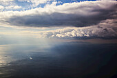 A Lone Boat On The Aegean Sea Under A Cloudy Sky And Distant View Of The Coastline; Greece