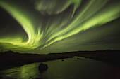Nordlicht, oder Aurora Borealis, leuchtend über einem Strom; Island