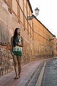 A Young Chinese Woman Walking Around Downtown Alcala De Henares, A Historical And Charming City Near To Madrid; Alcala De Henares, Spain