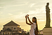 Junge chinesische Frau, die ein Foto mit ihrem Telefon macht; Cuenca, Kastilien-La Mancha, Spanien