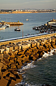 Blocks Of Rock Piled Against A Wall In The Harbour, Near Conil De La Frontera; Andalusia, Spain