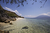 White Sand Beach With Clear Water And Offshore Volcano On The Horizon