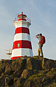 Hiker Looking Out Over Brier Island Lighthouse, Bay Of Fundy; Brier Island, Nova Scotia, Canada