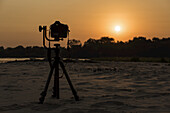 Kamera auf Stativ neben dem Fluss bei Sonnenuntergang; Mato Grosso Do Sul, Brasilien