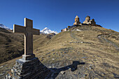 Stone Cross And Gergeti Trinity Church With Mount Kazbek In The Background; Kazbegi, Mtskheta-Mtianeti, Georgia