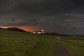 Souter-Leuchtturm entlang der Küste unter bedrohlichen Sturmwolken; South Shields, Tyne And Wear, England