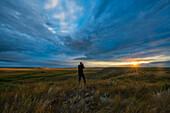 Eine Person fotografiert den Sonnenaufgang im Grasslands National Park; Saskatchewan, Kanada