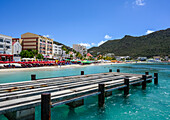 Dock at the waterfront with resorts and people along the beach; Philipsburg, St Maarten