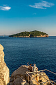 Pärchen genießt den Sonnenuntergang und die Aussicht auf die Insel Lokrum; Dubrovnik, Gespanschaft Dubrovnik-Neretva, Kroatien
